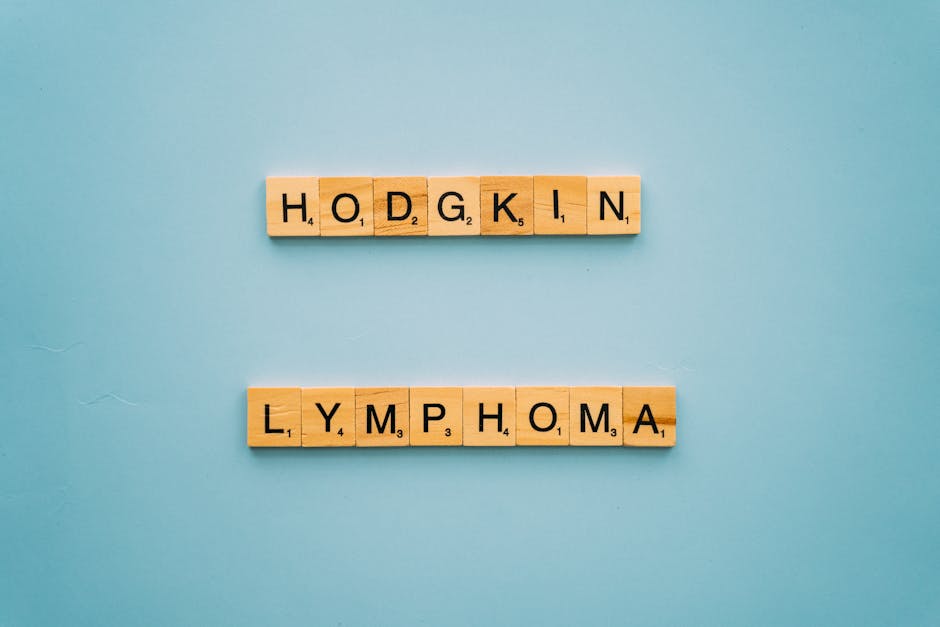 Wooden letters spell Hodgkin Lymphoma, conveying a health awareness message on blue background.
